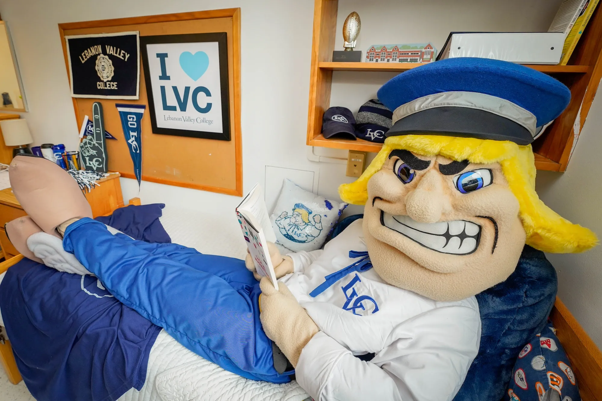 Dutchman mascot reads in dorm room