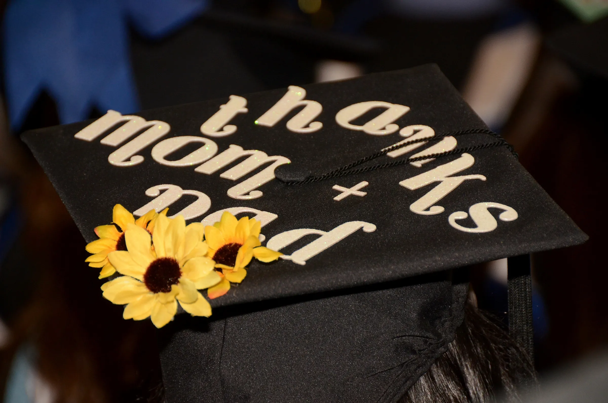 Decorated grad cap that says, "thanks mom and dad"