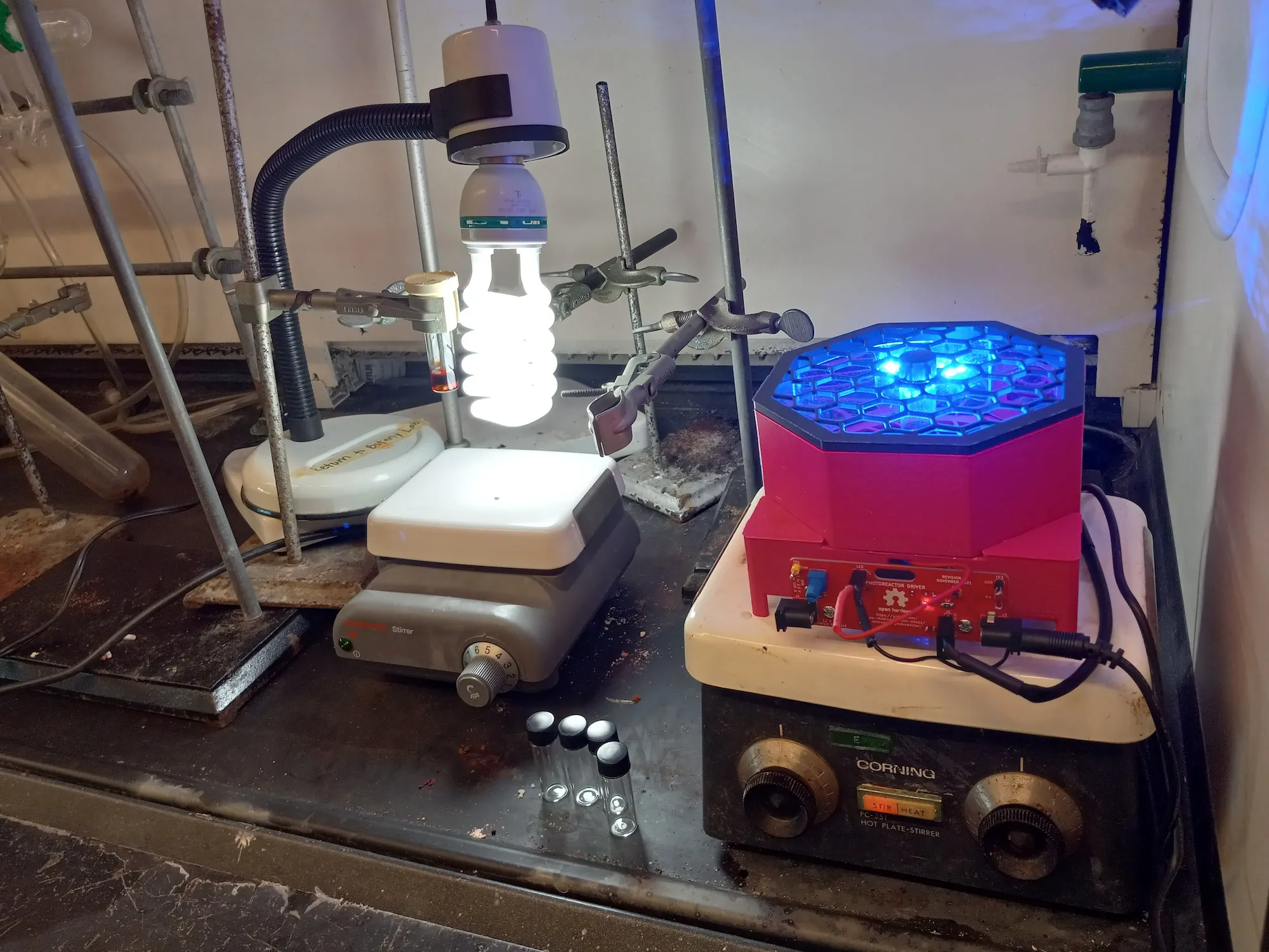 A side-by-side comparison of LVC Chemistry's new LED photoreactor with the older white lightbulb